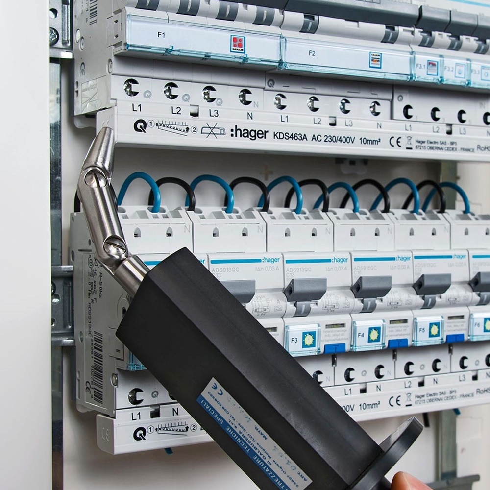 Elektriker prüft/misst mit technischem Gerät Berührungsschutz im Hager Zählerschrank