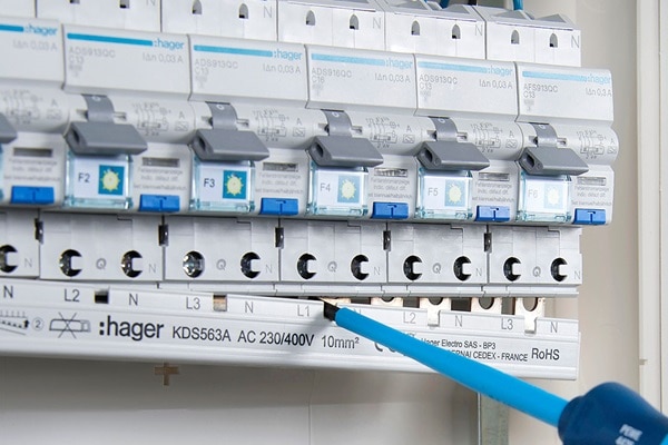 Elektriker lockert/entfernt mit Schraubendreherwaagerechte Phasenschiene Hager KDS563A