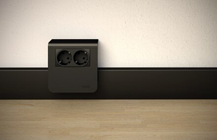 Blick auf Hager tehalit Sockelleistensystem in Schwarz, Sockelleiste mit Geräteträger und Einbaugerät 2-fach Steckdose