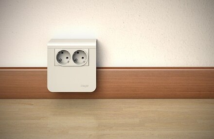 Blick auf Hager tehalit Sockelleistensystem, Sockelleiste in Kirschholz-Optik, Geräteträger und Einbaugerät 2-fach Steckdose in Silber 