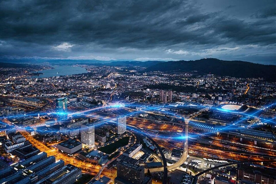 Luftaufnahme eines Stadtgebiets bei Nacht mit beleuchteten Straßen und Gebäuden, zeigt städtische elektrische Infrastruktur