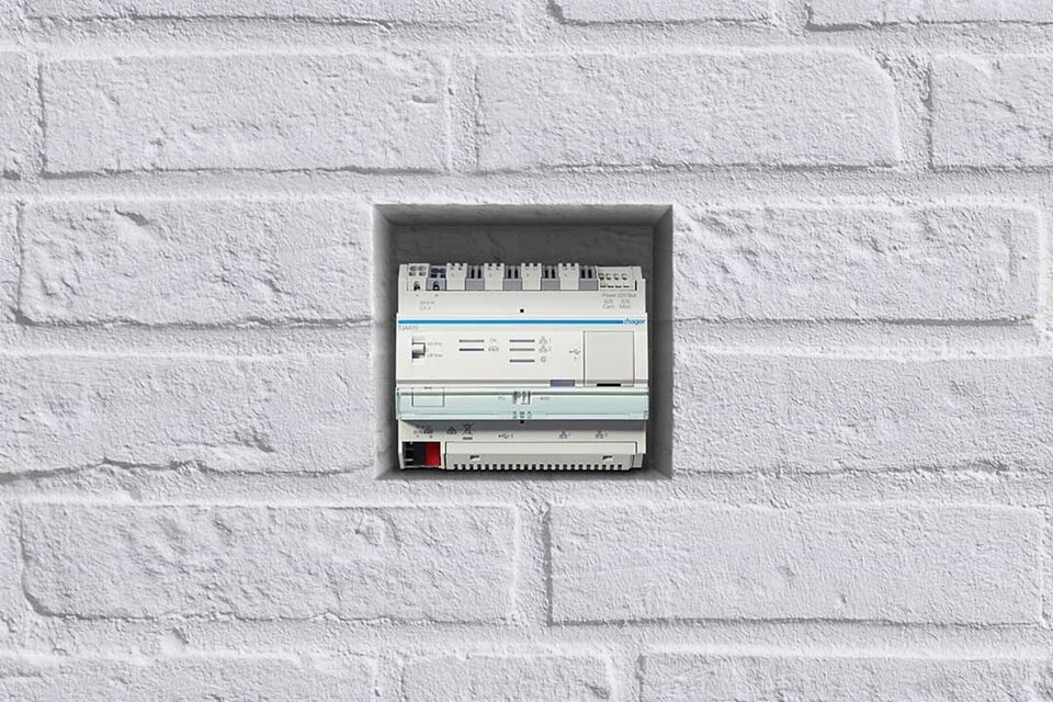 Hager Verteilerkasten für die elektrische Energieverteilung, montiert an einer weißen Ziegelwand