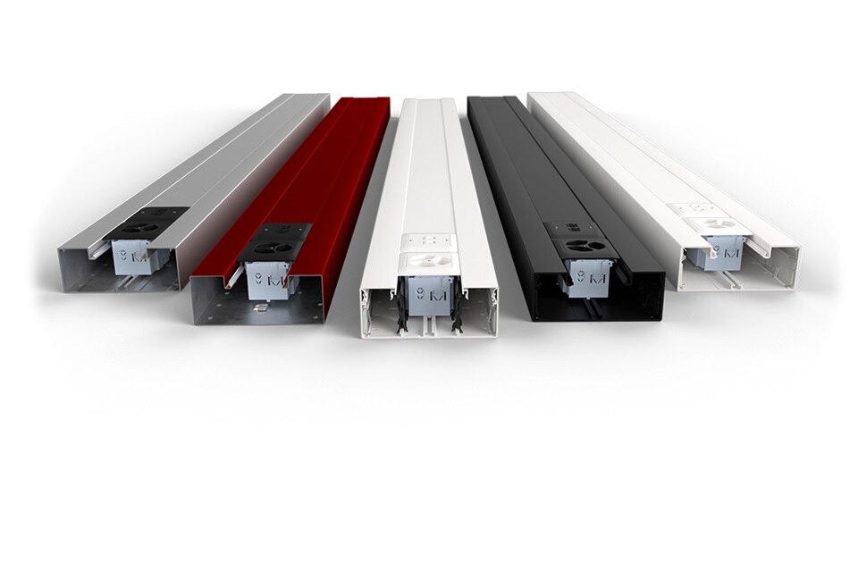 Verschiedenfarbige Kabelkanalsysteme mit integrierten Elektrosteckdosen auf weißem Hintergrund