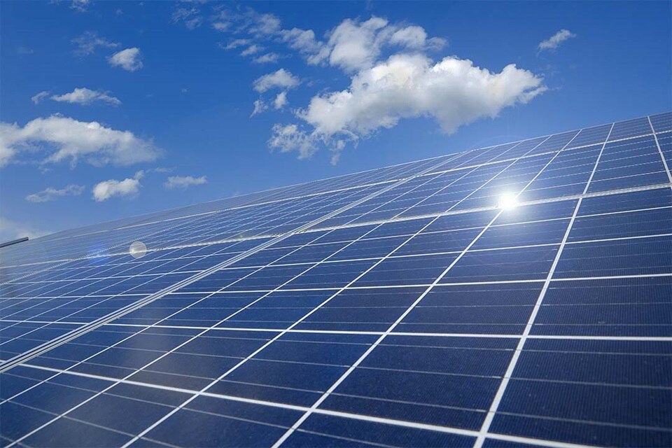 Solarmodule mit blauem Himmel und Wolken im Hintergrund