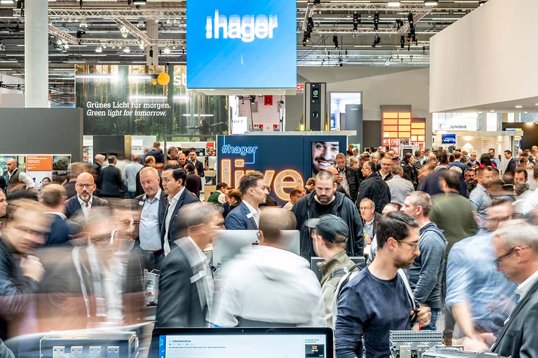 Überfüllte Messehalle mit Besuchern am Hager-Stand, der elektrische Lösungen für Automatisierungs- und Steuerungssysteme präsentiert.