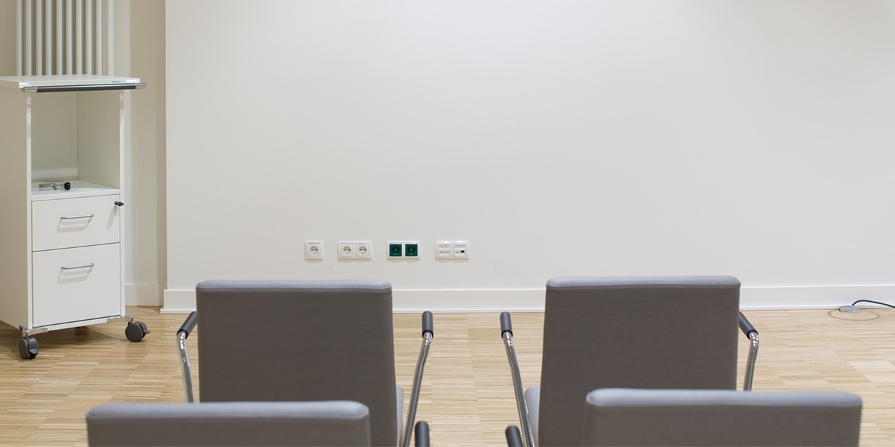 Leeres modernes Büro mit Stühlen, Steckdosen und Datendosen an der Wand