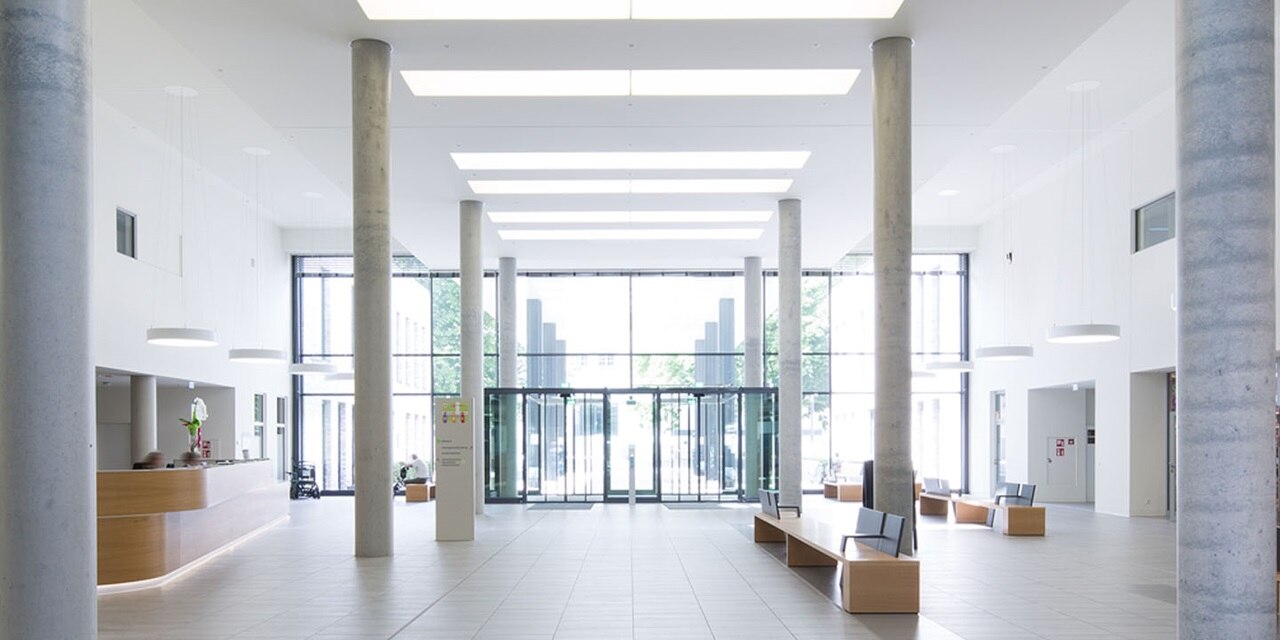 Geräumige Lobby mit modernen Beleuchtungskörpern, einer Rezeption und Sitzbereich