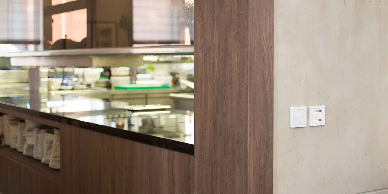 An einer Wand montierte Lichtschalter neben einer Theke eines Cafés