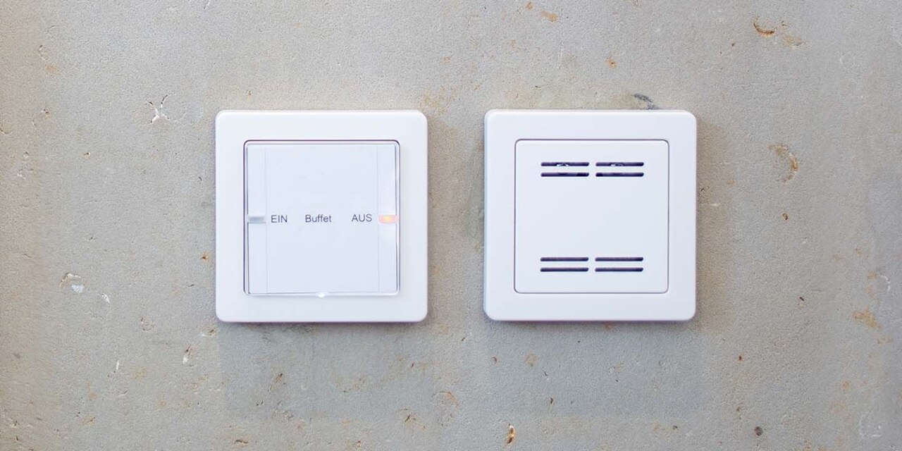 Weißer Lichtschalter und Dimmer an Betonwand