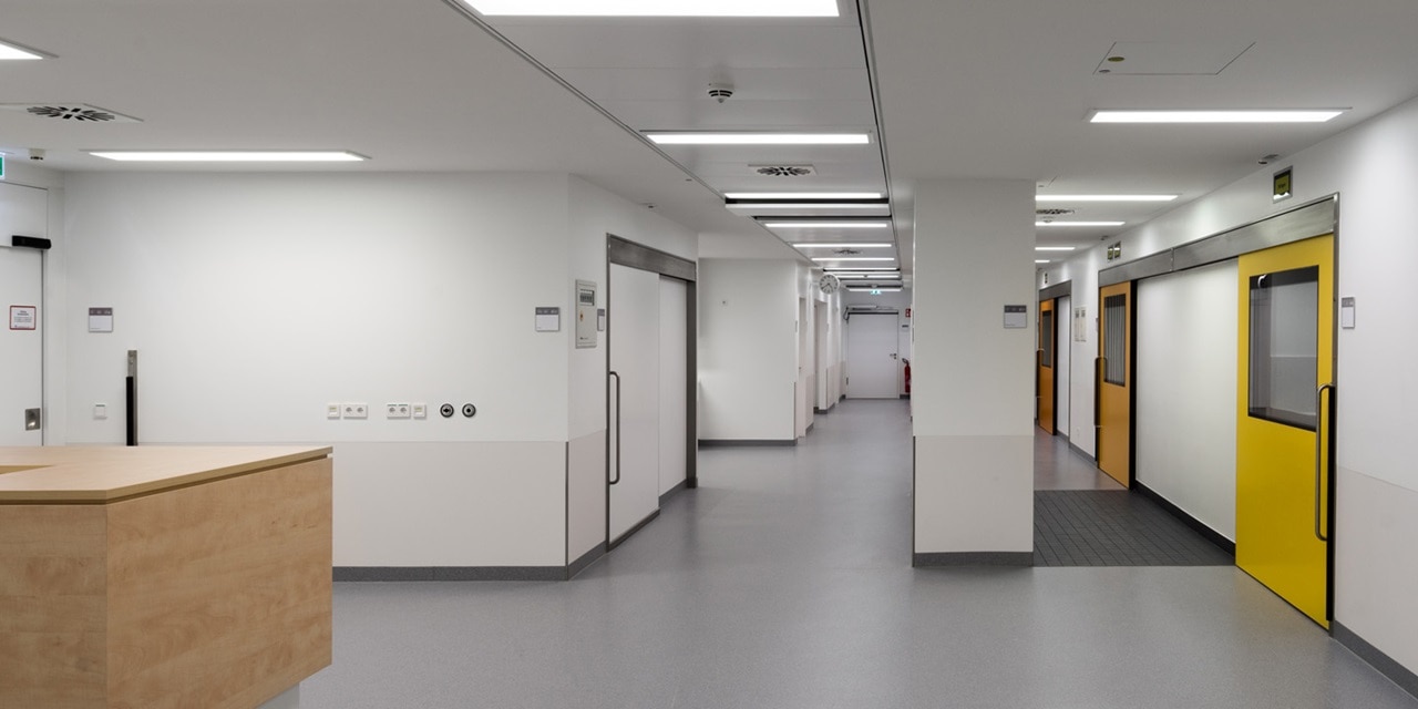 Moderner Krankenhausflur mit sauberem Design, Elektrosteckdosen und Sicherheitsschildern