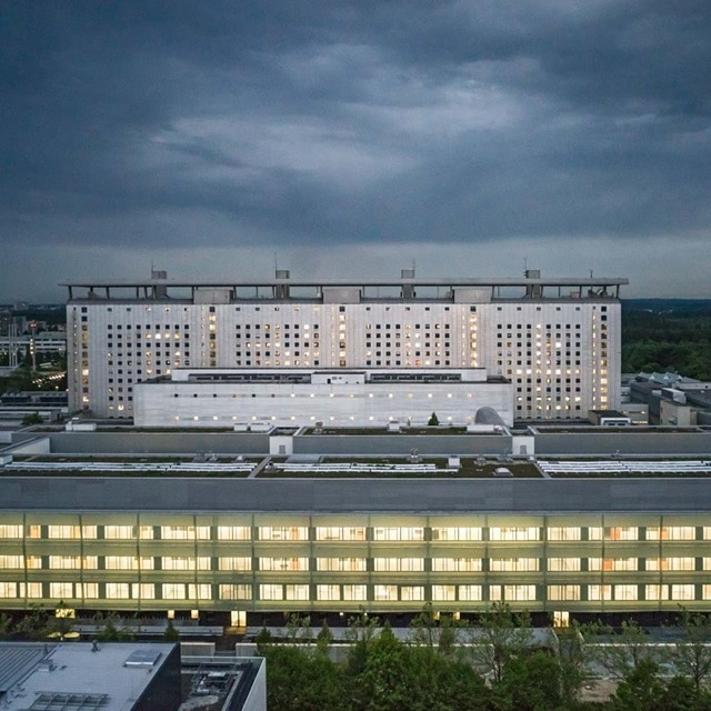 Modernes Gewerbegebäude im Zwielicht mit bewölktem Himmel beleuchtet