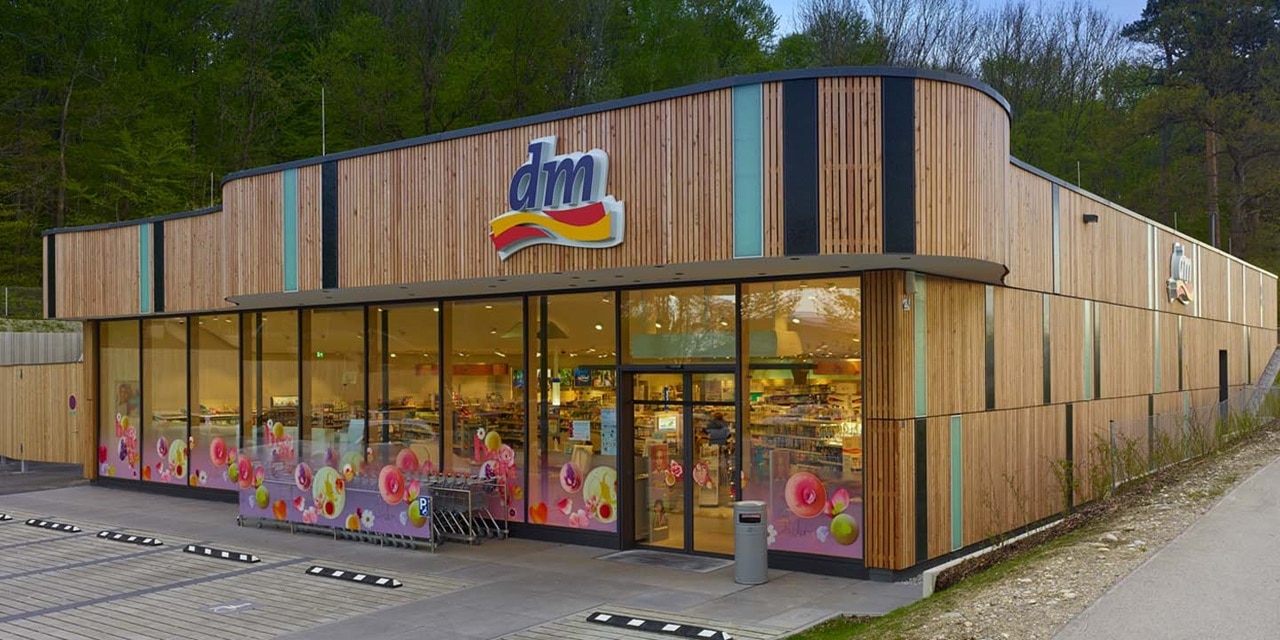 Modernes dm-drogerie markt Geschäftsexterieur mit Holzfassade und großen Glasfenstern