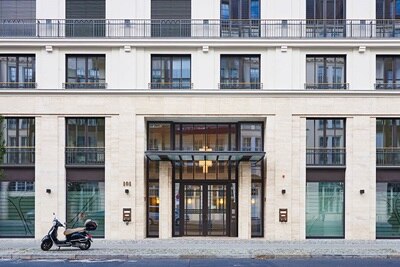 Moderne Gebäudefassade mit Eingangstür und geparktem Roller