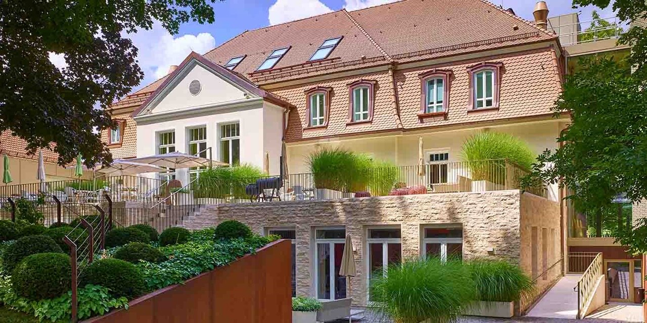 Modernes Wohngebäude mit Balkonen und gepflegtem Garten