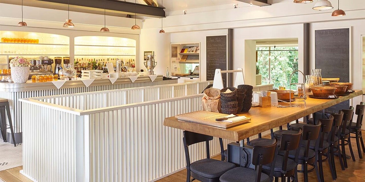 Modernes Restaurant-Interieur mit Tresen, stilvollen Hängeleuchten und Kreidetafeln