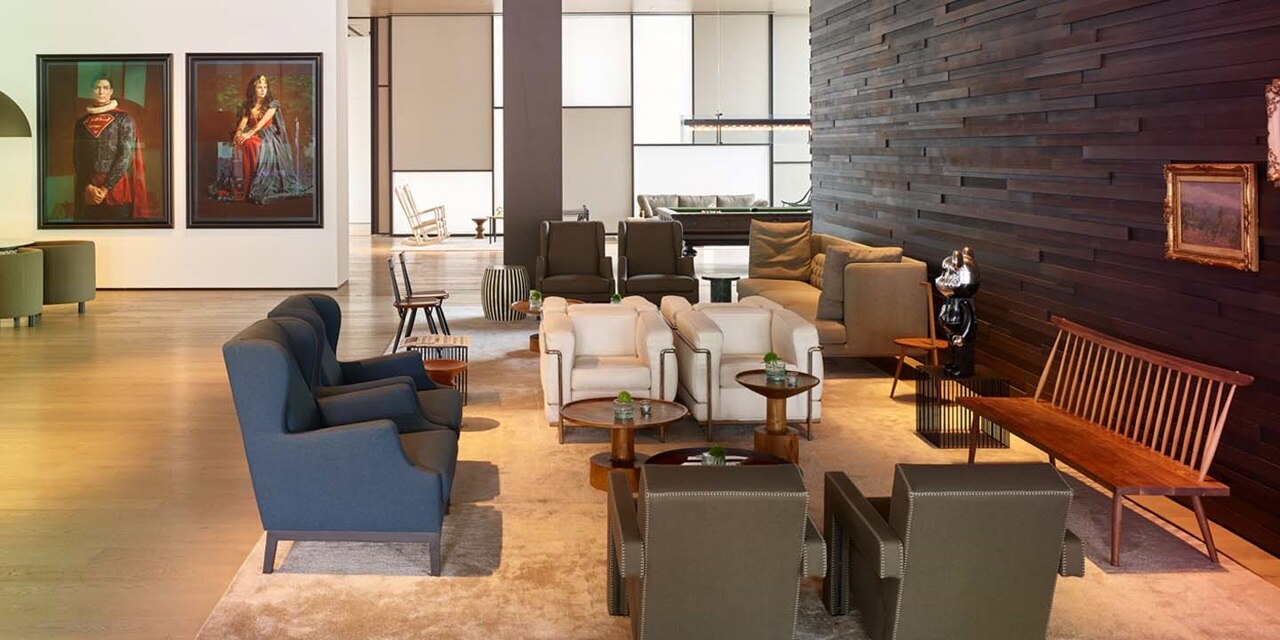 Modern gestaltetes Lobby-Interieur mit verschiedenen Sitzgelegenheiten und eleganter Dekoration, mit Holzverkleidung und Kunstwerken