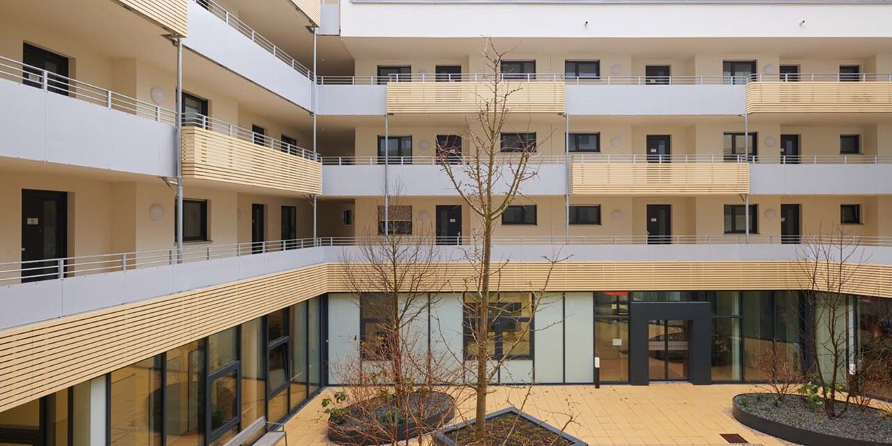 Modernes Wohngebäude mit Balkonen und einem zentralen Innenhof