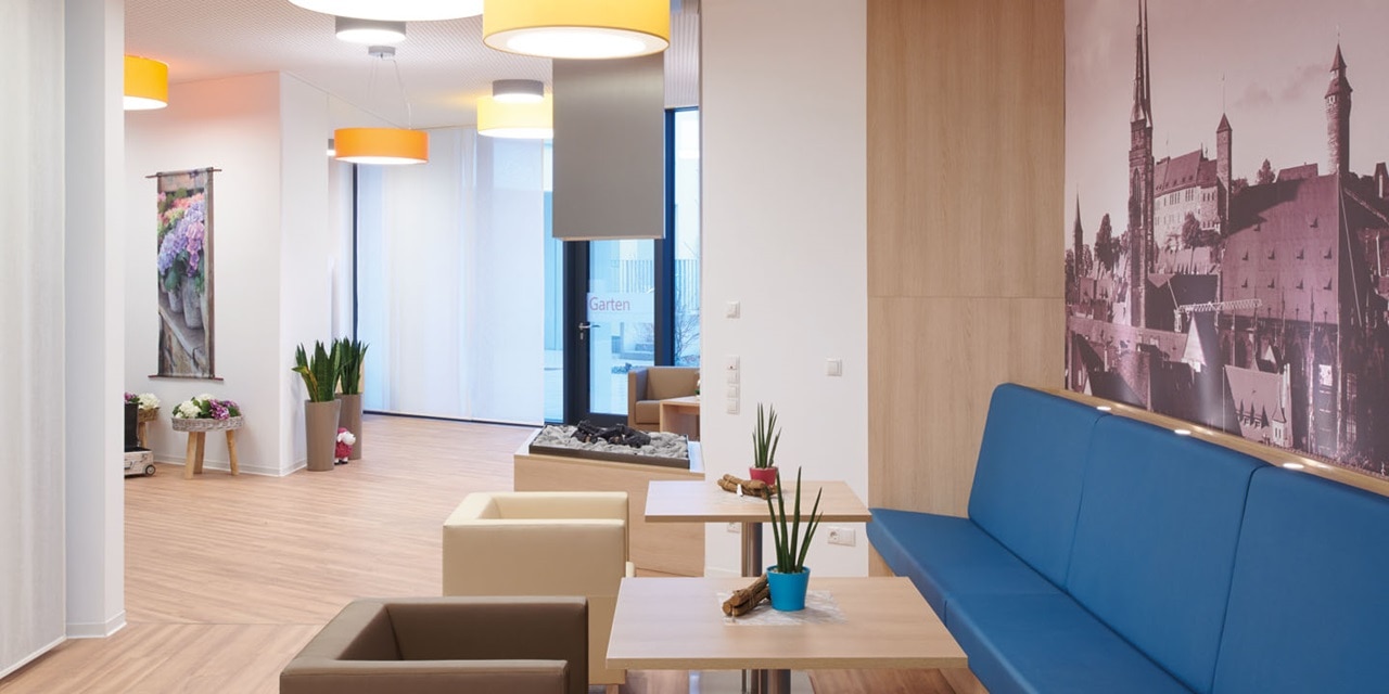 Modernes Bürofoyer mit hängenden Beleuchtungskörpern und gemütlicher Sitzbereich
