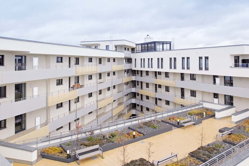 Modernes Wohngebäudekomplex mit Balkonen und einem Innenhofgarten