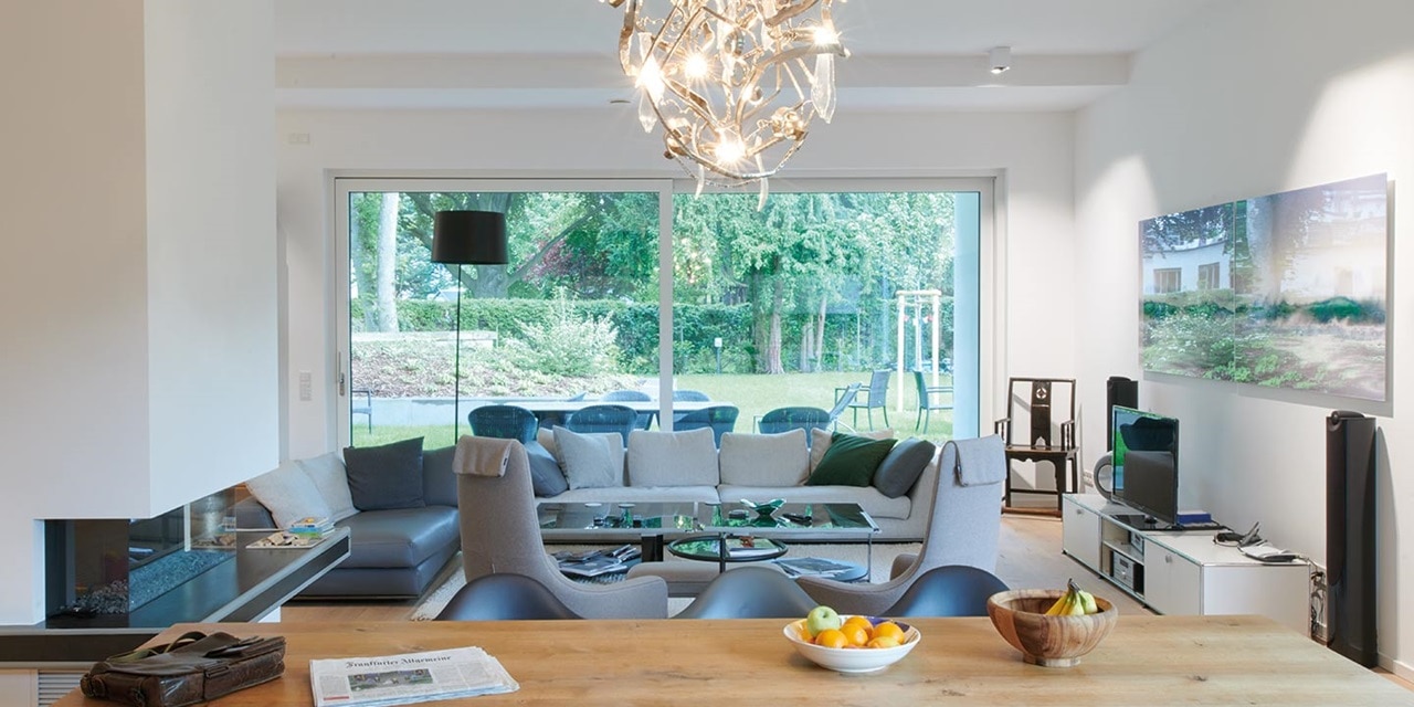 Modernes Wohnzimmer mit stilvollem Kronleuchter, großem Fenster und gemütlicher Sitzgelegenheit