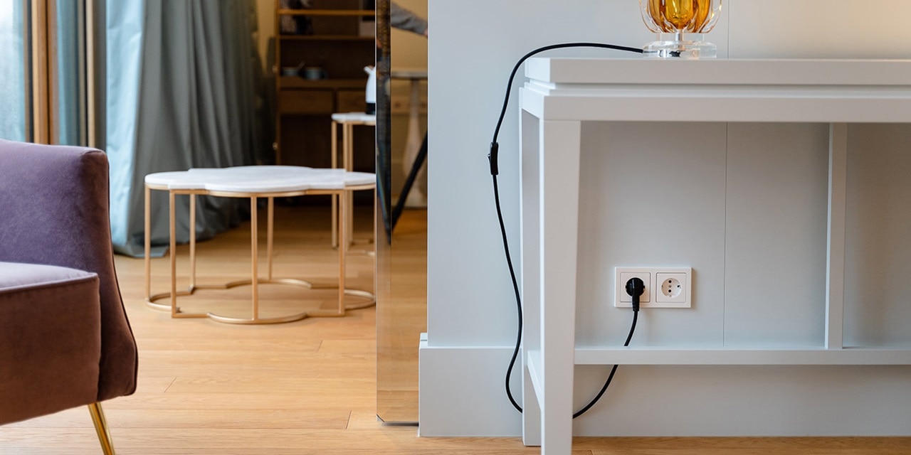 Modernes Wohnzimmer mit weißer Steckdose und eingestecktem Kabel