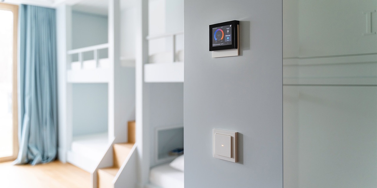 Modernes Wohninterieur mit Smart-Home-Steuerungspanel an der Wand und Lichtschalter