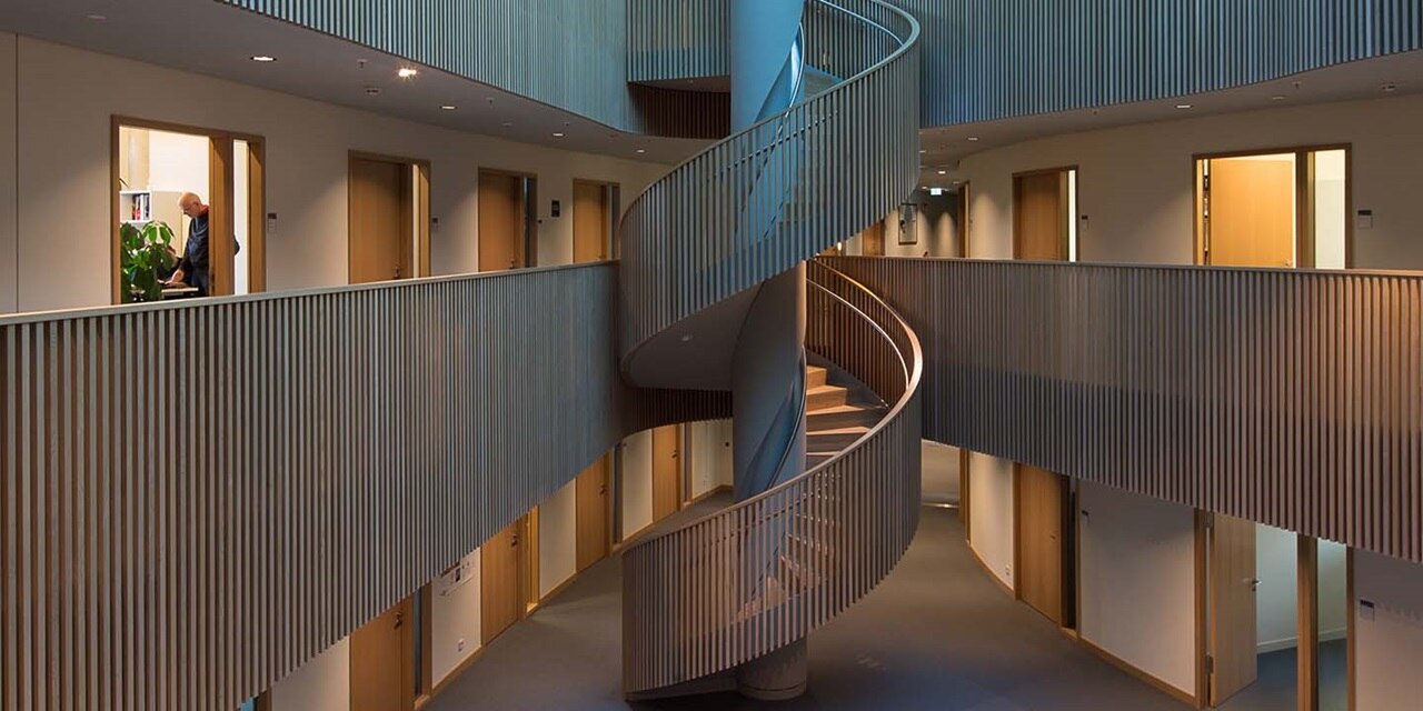 Modernes Bürointerieur mit Wendeltreppe und gehender Person