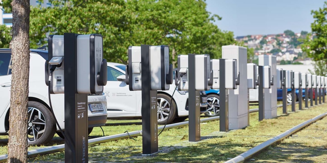Elektrofahrzeuge beim Laden an einer Reihe von Ladestationen mit Hager-Markenzeichen