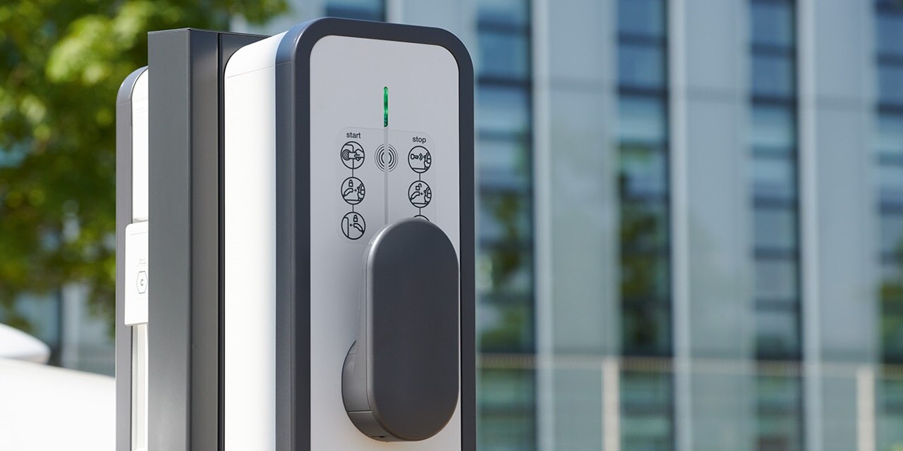 Außenliegende Elektrofahrzeug-Ladestation mit Bedienungsanleitungen und LED-Statusanzeige im städtischen Umfeld