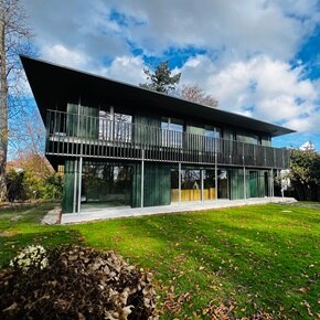 Seitenwinkel-Ansicht des Hauses am Ammersse mit dem flow Energiemanagement inklusive notstromfähigem Energiespeicher und PV-Wallbox