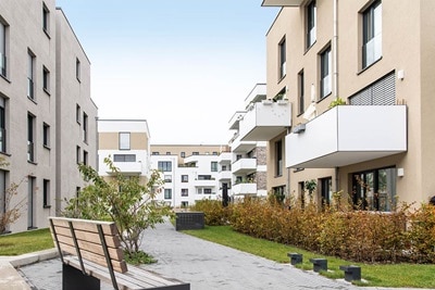 Modernes Wohnhauskomplex mit Balkonen und landschaftlich gestaltetem Innenhof