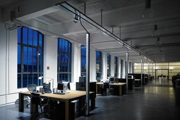 Innenansicht eines Großraumbüros in einem Altbau mit Kabelführung über die Decke