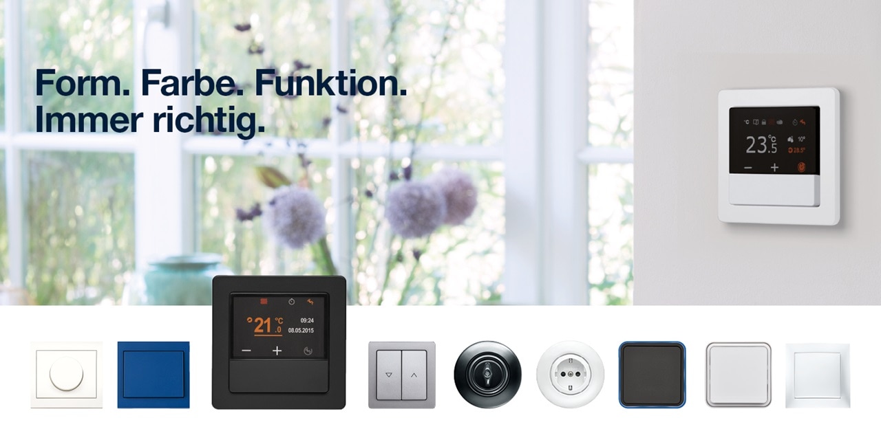 Komponenten des Hager-Hausautomationssystems mit intelligentem Thermostat an der Wand sowie verschiedenen Designs für Schalter und Steckdosen
