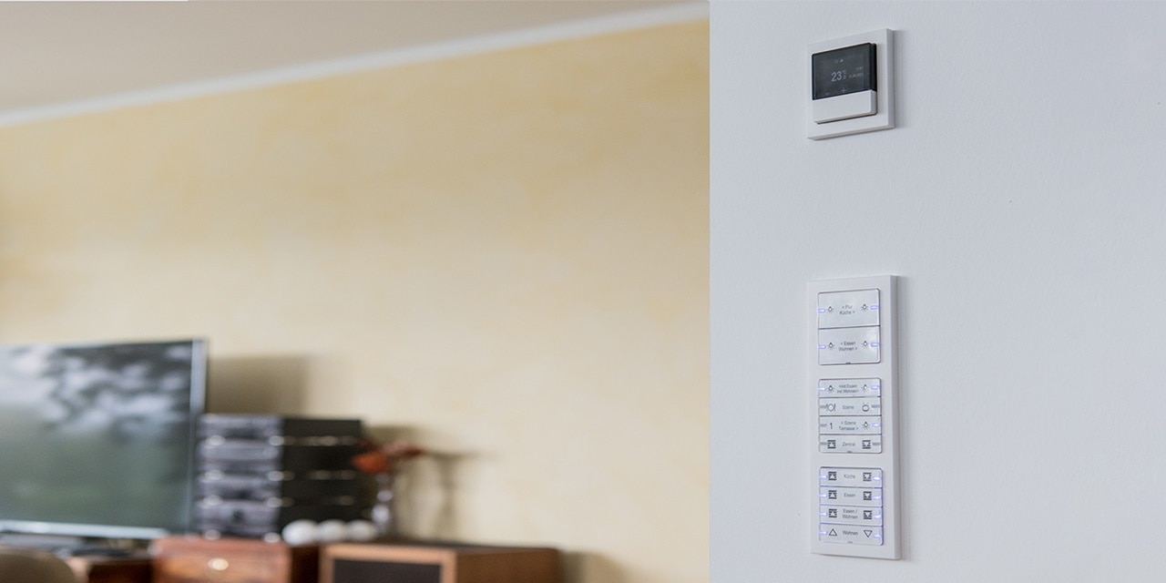 Smart-Home-Thermostat und Bedienfeld an der Wohnzimmerwand