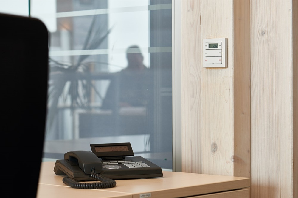 Beispiel einer Installation Berker Q.3 Taster und Temperaturregler mit LC-Display in Weiß auf Holzwand