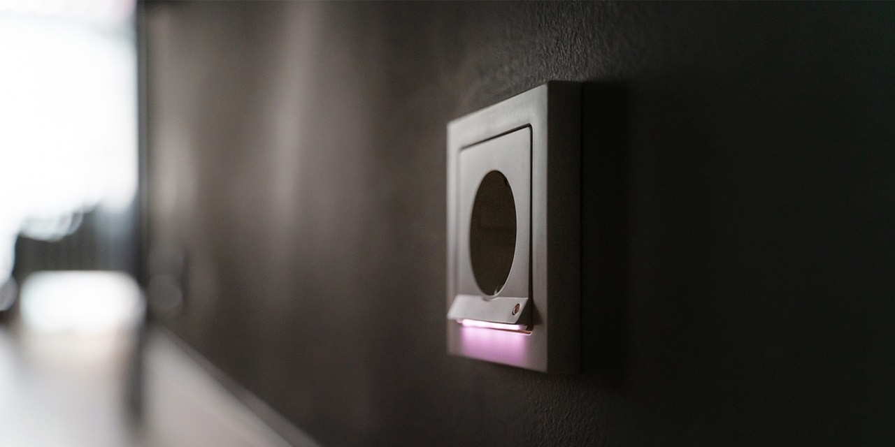 Moderner Lichtschalter an einer dunklen Wand mit LED-Anzeige