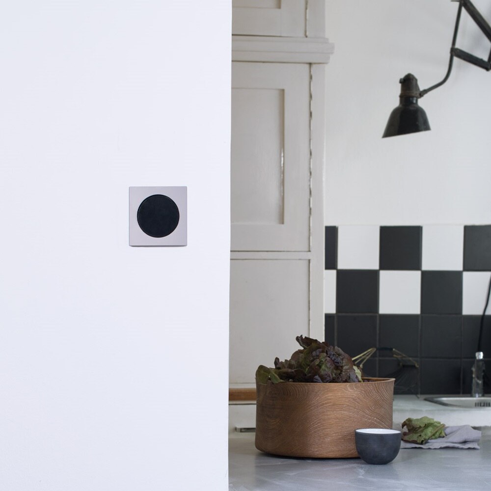 Beispiel einer Installation Berker R.3 Lichtschalter mit rundem Zentralstück in Schwarz und Rahmen aus Aluminium auf weißer Wand im Innenbereich