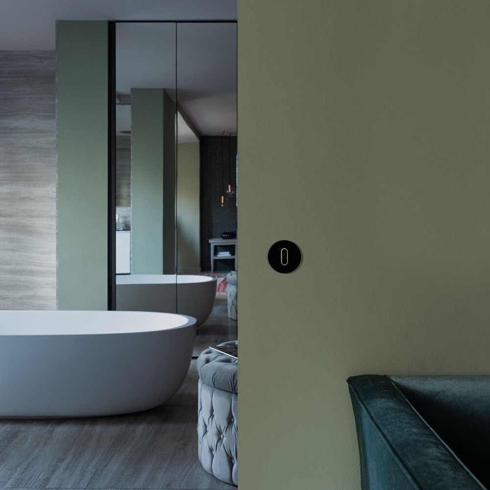 Beispiel einer Installation Berker Classic Lichtschalter mit Knebel und Abdeckplatte in Schwarz auf grüner Wand eines Badezimmers