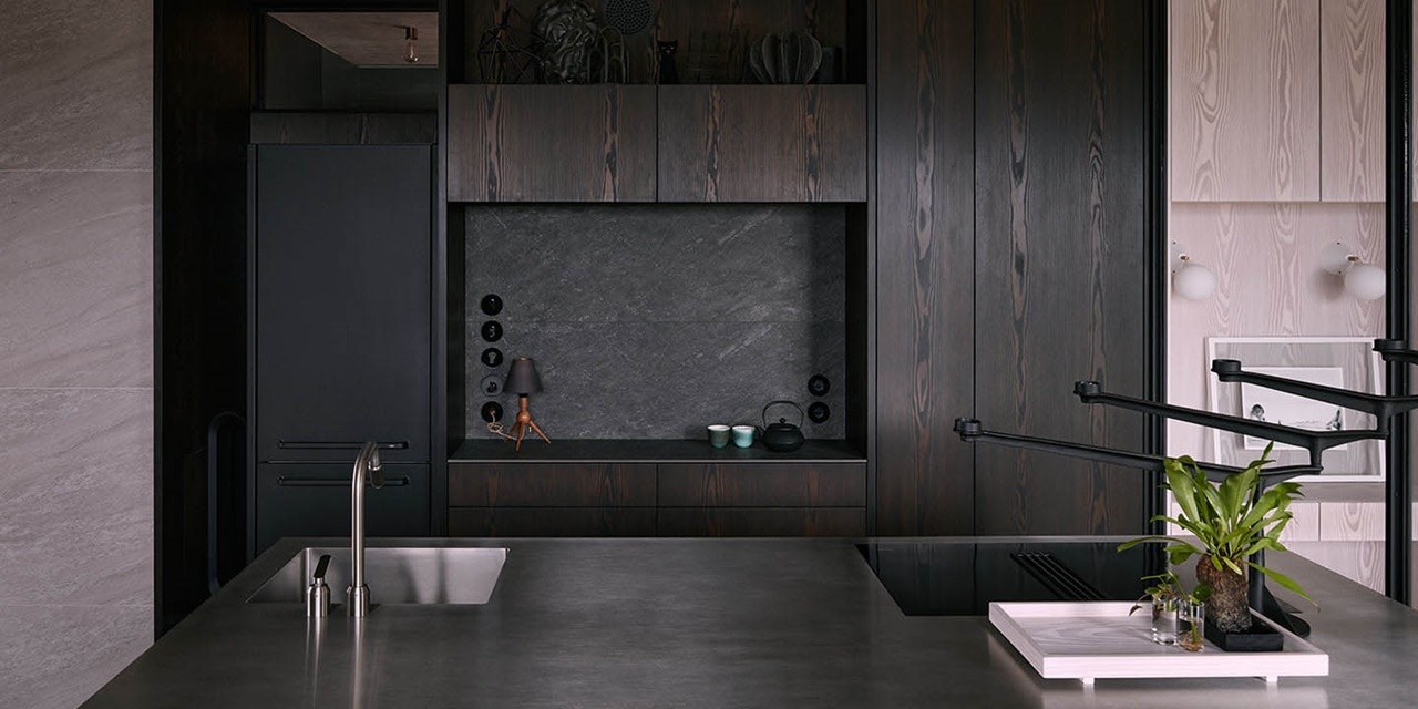 Modernes Kücheninterieur mit dunklen Holzschränken und Arbeitsplatte aus Edelstahl