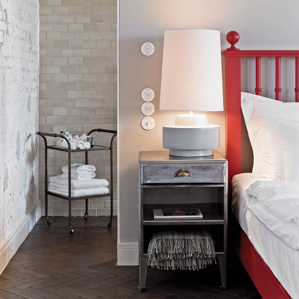Beispiel einer Installation Berker Serie 1930 Lichtschalter mit Knebel und Abdeckplatten in Weiß auf grauer Wand in Hotelzimmer