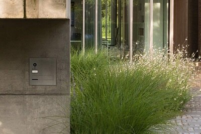 Blick auf Elcom Video-Türsprechanlage, Installation Unterputz in Sichtbetonwand im Außenbereich vor Gebäude