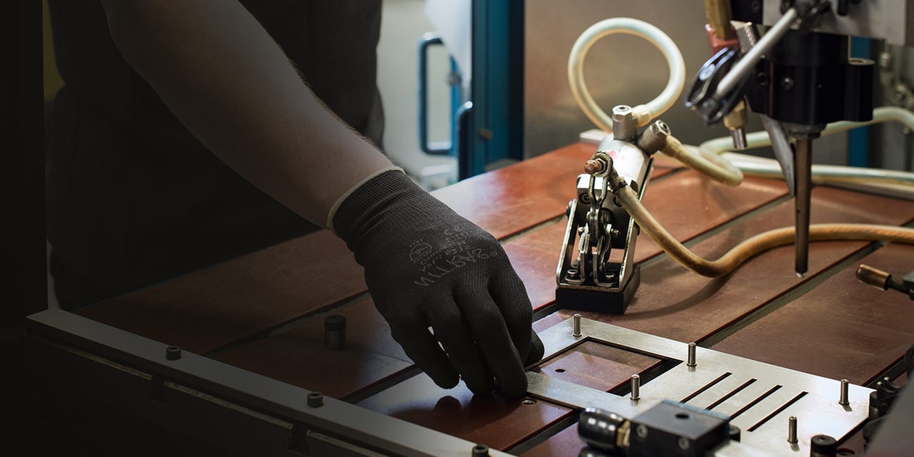 Person montiert elektrische Komponenten auf einer Werkbank mit einem pneumatischen Gerät
