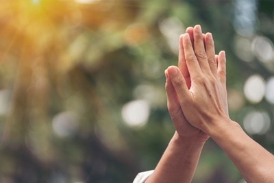 Zwei Hände eines Manns und einer Frau, die sich vollflächig mit nach oben zeigenden Fingern berühren