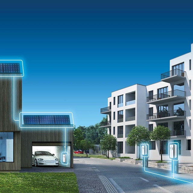 Modernes Wohngebäude mit Solarpanels und Elektrofahrzeug-Ladestationen, hervorgehoben zur Darstellung von Energieeffizienz und Nachhaltigkeit