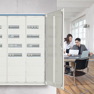 Blick in Büro mit Hager Feldverteiler mit 3 Feldern im Vordergrund und darin installierten elektrischen/elektronischen Baugruppen