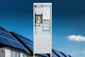 Frontalansicht geöffnete Hager Zähleranschlusssäule für Außenbereich, Häuser mit PV-Anlage und blauer Himmel im Hintergrund