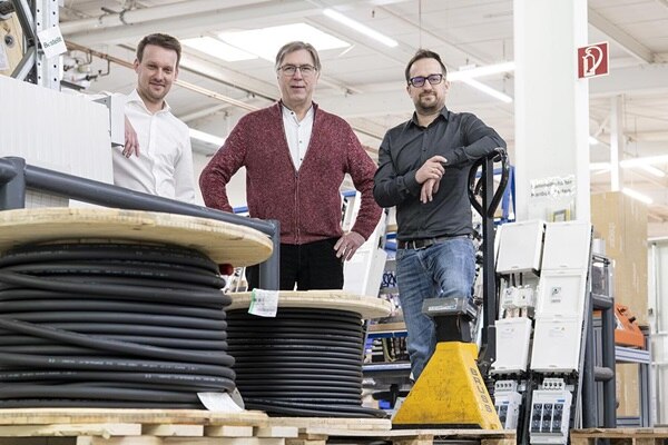 Drei Mitarbeiter von Hager mit Kernkompetenz Wanderanlagen in Fertigungshalle, Bildvariante 1