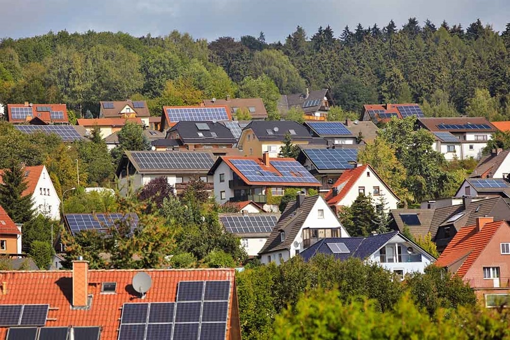 Blick auf Ortschaft mit roten Ziegeldächern und installierten PV-Anlagen