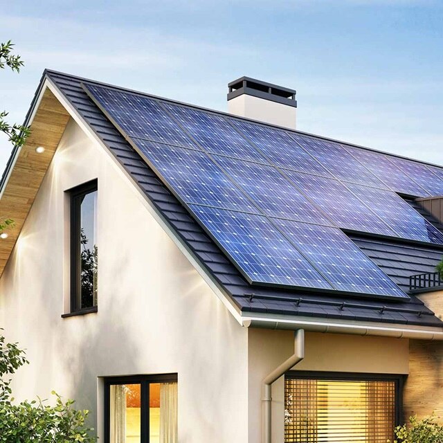 Blick auf Einfamilienhaus mit Schrägdach und darauf installierter PV-Anlage (Photovoltaik)