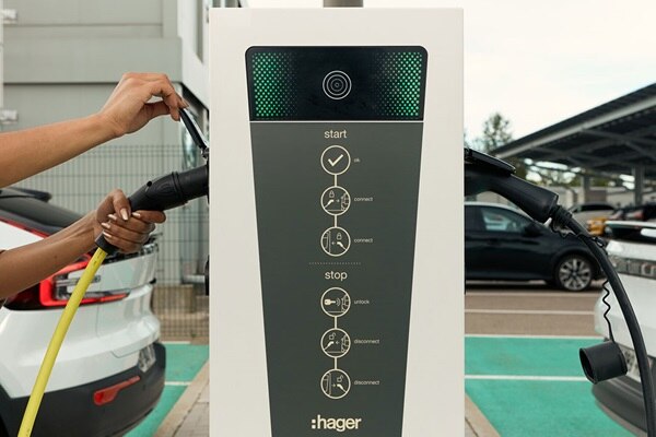 Frontalansicht der Hager Witty Ladesäule mit eingesteckten Ladekabeln von Elektroautos links und rechts